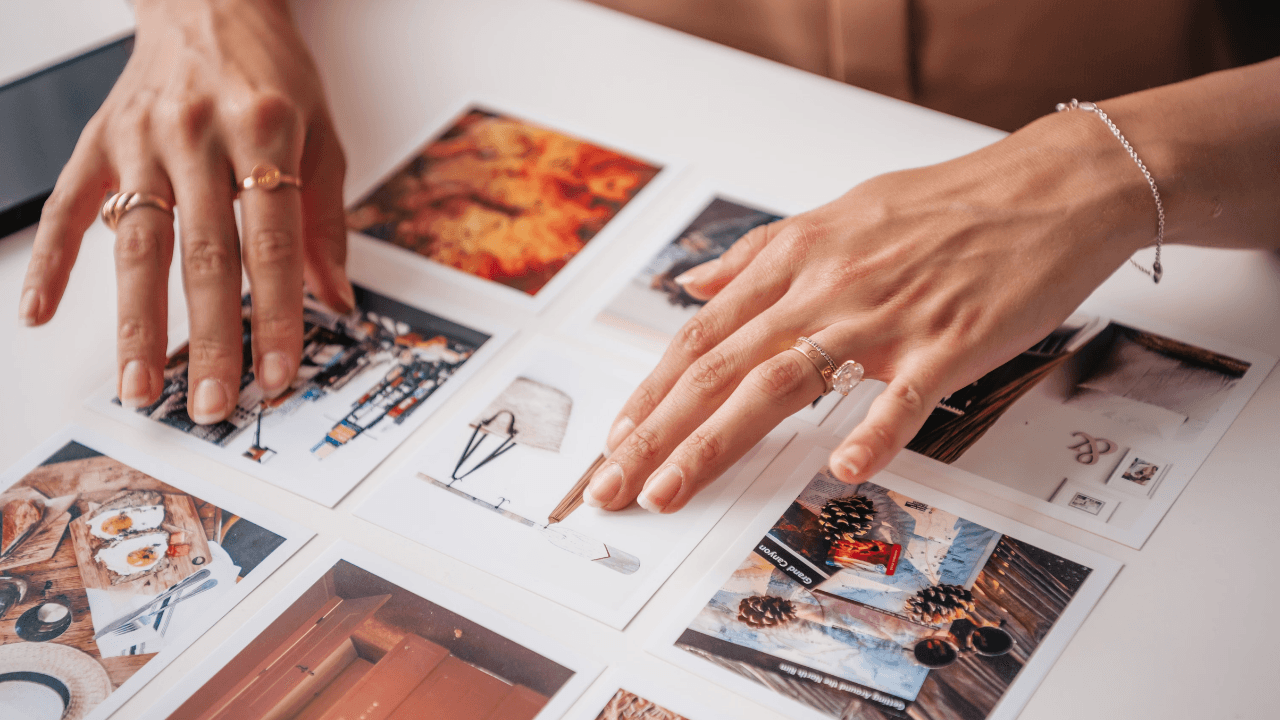 Hands arranging printed photographs